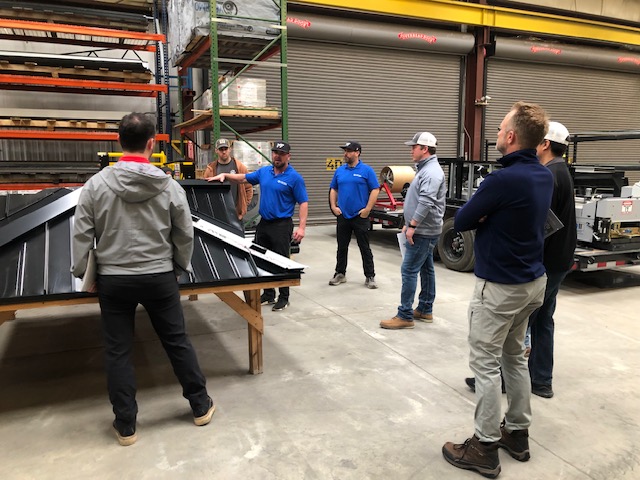 metal formers worker instructing group about metal roofs