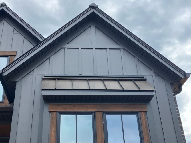 A grey sided building with a metal roof and drip edges from Metal Formers.