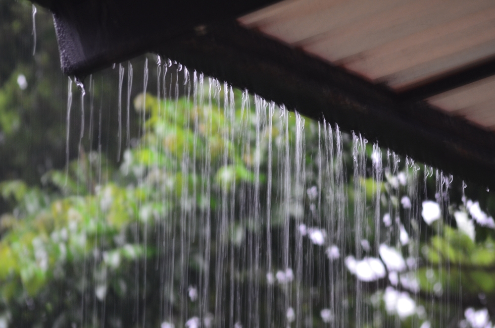 rain falling off the edge of a roof of a house