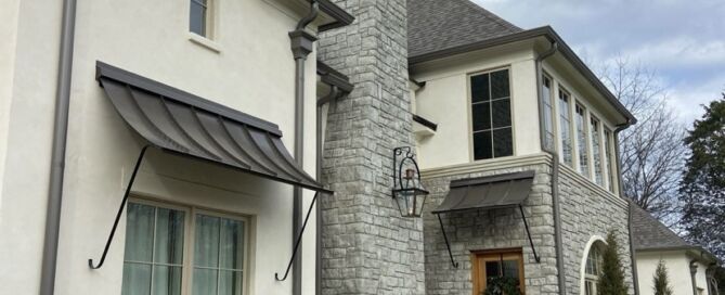 A house with metal awnings and shingles.