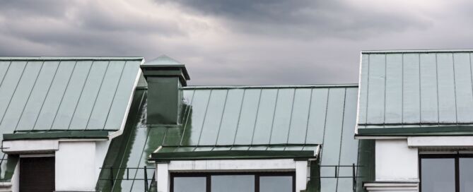 Standing seam metal roof on a building under dark storm clouds