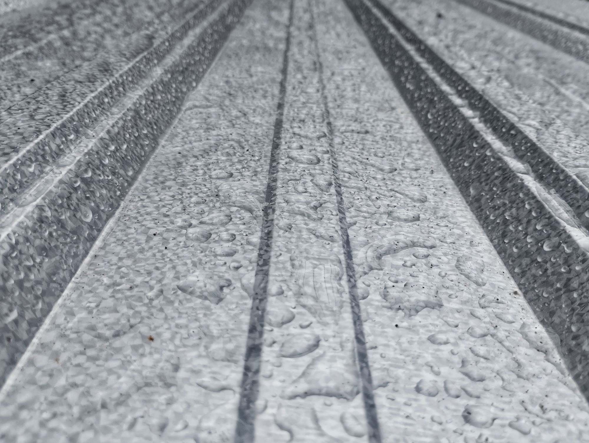 Close-up of condensation droplets beaded on ribbed metal roof panels